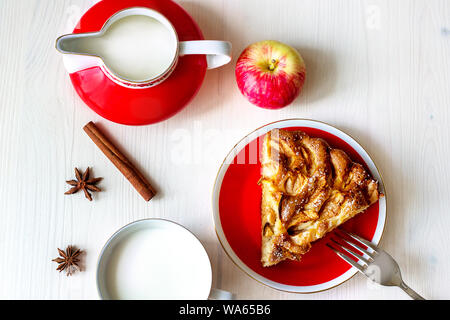 Stück frischen Apfelkuchen auf dem Teller mit Gabel, frischen Apfel, Gewürze, Milchkännchen Nahaufnahme Stockfoto
