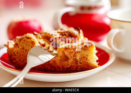 Ein Stück hausgemachten Obstkuchen mit Zimt auf den Teller mit Gabel, frischen Apfel und Tasse Kaffee Nahaufnahme Stockfoto