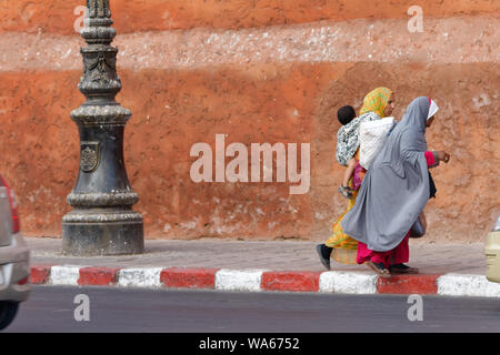 Zwei muslimische Frauen in tradiitonal Roben Überqueren der Straße Stockfoto