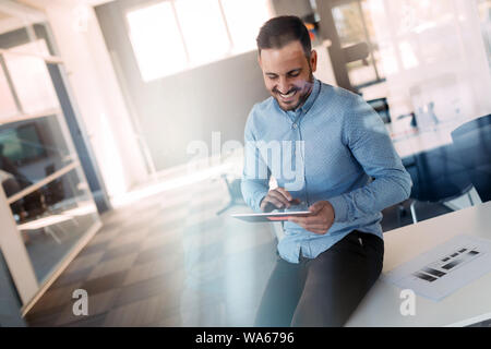 Portrait einer jungen erfolgreichen Manager mit Touchpad für Arbeitstag vorbereiten Stockfoto
