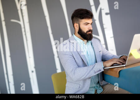 Konzentrierte sich ernsthafte Geschäftsmann in Anzug denken Lesen online News Stockfoto