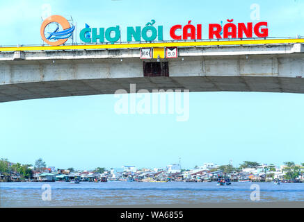 Text auf der Brücke 'Cai Rang Floating Market' führte zu Riverside Handel mit Dutzende Boote am Ufer des Flusses serviert traditionelle Neues Jahr landwirtschaftliche in Can Tho Stockfoto