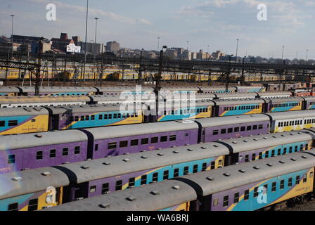 Bunte Nahverkehrszüge auf einem Abstellgleis in Johannesburg, Südafrika Stockfoto