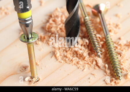 Bohren und Schrauben auf einem Holzbrett Stockfoto