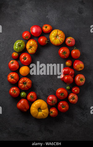 Tomate Wort mit reifen Tomaten auf einem schwarzen Hintergrund, kreative Flach gesundes Essen Konzept. Stockfoto