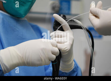 (190818) - CHANGSHA, Aug 18, 2019 (Xinhua) - Arzt Xiao Yangbao trägt auf endoskopische Untersuchungen für einen Patienten bei der Endoskopie Zentrum von Hunan Chest Hospital in Changsha, der Hauptstadt der zentralchinesischen Provinz Hunan, Nov. 14, 2019. Xiao Yangbao, ein 39-jährige Arzt in der Endoskopie Zentrum von Hunan Chest Hospital, arbeitet an einer Tuberkulose Prävention und Behandlung für fast 8 Jahre. Als Arzt Ausführung von Endoskopie, Xiao ist angesichts der höheren Risiken für Tuberkulose und höhere Betrieb Anforderungen an Genauigkeit und Konzentration. Xiao fühlt sich immer dankbar everytime h Stockfoto