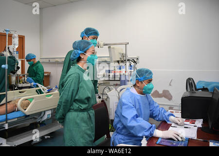 (190818) - CHANGSHA, Aug 18, 2019 (Xinhua) - Arzt Xiao Yangbao (1. R) prüft den Zustand eines Patienten vor der endoskopischen Untersuchung bei einer Endoskopie Zentrum von Hunan Chest Hospital in Changsha, der Hauptstadt der zentralchinesischen Provinz Hunan, Nov. 14, 2019. Xiao Yangbao, ein 39-jährige Arzt in der Endoskopie Zentrum von Hunan Chest Hospital, arbeitet an einer Tuberkulose Prävention und Behandlung für fast 8 Jahre. Als Arzt Ausführung von Endoskopie, Xiao ist angesichts der höheren Risiken für Tuberkulose und höhere Betrieb Anforderungen an Genauigkeit und Konzentration. Xiao fühlen sich immer Stockfoto