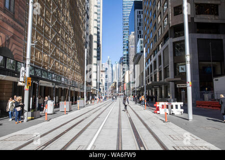 Sydney City Centre Büro Arbeiter auf der George Street im zentralen Geschäftsviertel zu Fuß über abgeschlossen Sydney Light Rail Tracks, Sydney, Australien Stockfoto