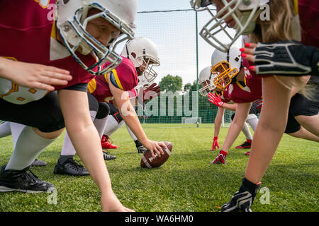 Foto von Athleten Frauen tragen weiße Helme spielen American Football am Sportplatz Stockfoto