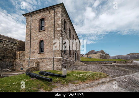 Charles Fort, Sommer Bucht, Kinsale, County Cork, Irland - 15. Mai 2019. Zwei Kanonen sitzen auf der Wiese vor dem Haus des Officer bei Charles Fort Stockfoto