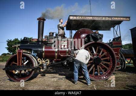 Männer reinigen und ihren Antrieb Motor polnische wie es oben an drusilla's Inn, in der Nähe von Horton, Dorset dampft, als Dutzende von Dampf angetriebene Fahrzeuge bereiten den Weg in die Great Dorset Steam Fair, wo sie von Tausenden Fans feiern Dampfkraft ab 22. August Wochenende verbunden wird. Stockfoto