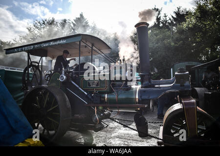 Eine Zugmaschine dampft an drusilla's Inn, in der Nähe von Horton, Dorset, als Dutzende von Dampf angetriebene Fahrzeuge bereiten den Weg in die Great Dorset Steam Fair, wo sie von Tausenden Fans feiern Dampfkraft ab 22. August Wochenende verbunden wird. Stockfoto