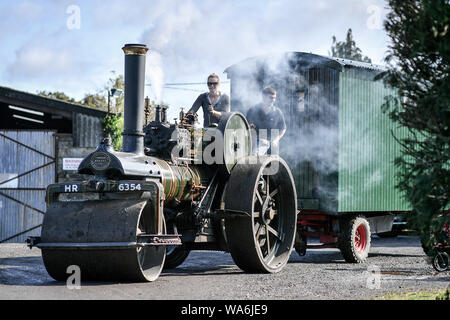 Eine Zugmaschine dampft, es hinterlässt Drusilla's Inn, in der Nähe von Horton, Dorset, als Dutzende von Dampf angetriebene Fahrzeuge bereiten den Weg in die Great Dorset Steam Fair, wo sie von Tausenden Fans feiern Dampfkraft ab 22. August Wochenende verbunden wird. Stockfoto