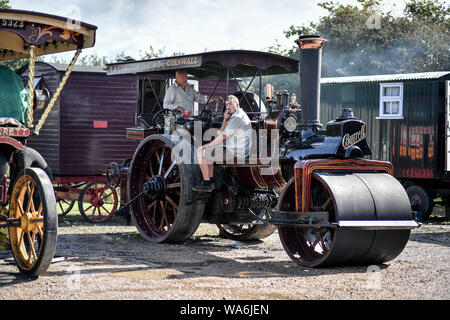 Männer auf einer Zugmaschine entspannen, wie es oben an drusilla's Inn, in der Nähe von Horton, Dorset dampft, als Dutzende von Dampf angetriebene Fahrzeuge bereiten den Weg in die Great Dorset Steam Fair, wo sie von Tausenden Fans feiern Dampfkraft ab 22. August Wochenende verbunden wird. Stockfoto