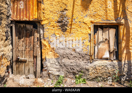 Traditionelle hölzerne Eingangstür und Fenster eines verlassenen shanty Haus Stockfoto