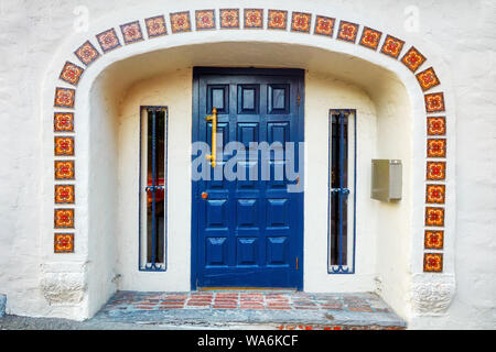 Der Eingang eines historischen Gebäude mit blauen Holztür und dekorative Fliesen an der Wand in Montreal, Kanada. Kanadische Architektur. Stockfoto