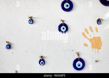 Dekorative Evil eye Beads hängend auf einer weißen Wand Stockfoto