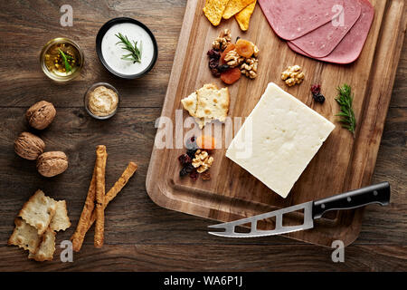 Türkische bryndza Schafskäse auf Holztisch mit Holz Schneidebrett und Messer. Ansicht von oben. Stockfoto