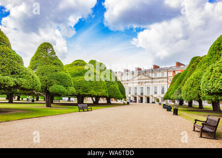 Vom 9. Juni 2019: Hampton Court, Richmond GROSSBRITANNIEN - östlich vor den Palast, über eine Allee von Eiben in der großen Springbrunnen Garten gesehen, mit einer Gruppe Stockfoto