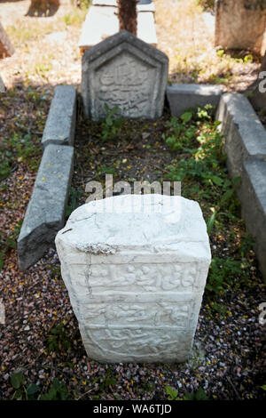 Historischen osmanischen Grabstein und ein Grab auf dem Friedhof in Hamamonu, Ankara, Türkei. Stockfoto