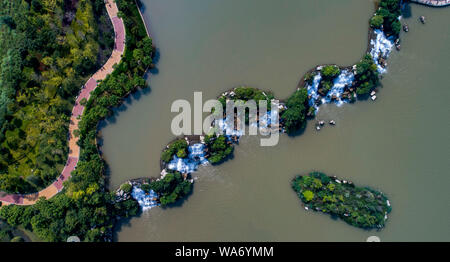 (190818) - Kunming, Aug 18, 2019 (Xinhua) - luftaufnahme am 12.08.17, 2019 zeigt eine Ansicht der Kunming Wasserfall Park in Kunming, Provinz Yunnan im Südwesten Chinas. Als Hauptstadt der Provinz Yunnan, Kunming ist nicht nur eine Verkehrs- und Informationsdrehscheibe, sondern auch ein regionales Zentrum für politische, wirtschaftliche, kulturelle, pädagogische, wissenschaftliche Forschung und soziale Dienste. Milden Klimas der Stadt ermöglichen, frischen Blumen und üppigem Grün das ganze Jahr über wachsen, machen ihn zu einem angenehmen Ort zu besuchen und im Leben. (Xinhua / Jiang Wenyao) Stockfoto