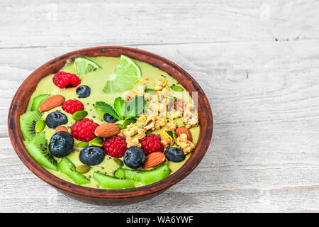 Grüne smoothie Schale aus Matcha Tee mit frischen Früchten, Beeren, Nüsse, Samen für eine gesunde vegane, vegetarische Ernährung Frühstück. Nach oben Schließen Stockfoto