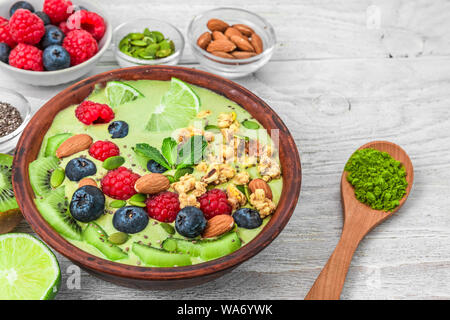 Matcha Grüntee smoothie Schüssel mit frischem Obst, Beeren, Nüsse, Samen und Müsli für gesunde vegetarische Ernährung Frühstück. Nach oben Schließen Stockfoto