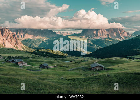 Wunderschöne Aussicht auf der Seiser Alm oder Seiser Alm mit langkofel oder Langkofel Berg in Wolken von Seceda bei Sonnenuntergang. Bergwiese mit Holz- c Stockfoto