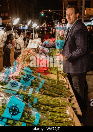 New York City, New York, Feb 14, 2018: Mann kauft Blumen zum Valentinstag von Straßenhändler in New York City Stockfoto