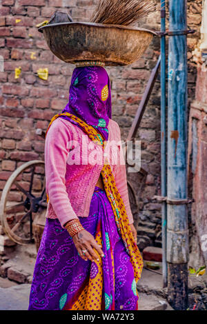 Barsana, Indien - 23. Februar 2018 - Frau trägt lila Schleier über Ihr Gesicht, während Ihr liefert die auf ihrem Kopf Stockfoto