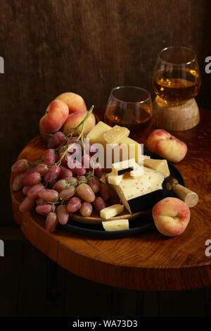 Käse, Trauben und Wein auf einem Holztisch, rustikalen Stil Stockfoto