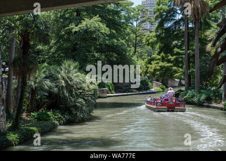 Ein Lastkahn mit Besuchern lagen ein Teil der San Antonio River, der Winde obwohl San Antonio lebhaft, unterirdischen Fluss laufen, was eine unansehnliche Slum in eine internationale Touristenattraktion geladen Stockfoto