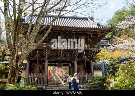 Japan, Miyajima. Daisho-in Tempel, Kikyozan Hokoin. Das Niomon Tor, den vorderen Eingang mit zwei Wächter Könige verankert. Frühling. Stockfoto