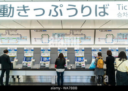 Japan, Hiroshima Station. Die Menschen in der Linie zu Tickets von Reihe von Billettautomaten kaufen. Overhead Display mit Karte. Stockfoto