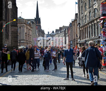 Royal Mile, Edinburgh, Schottland, Großbritannien. August 2019. Edinburgh Fringe, der Mann, der den World smallest Kite macht, flog eins über die Massen in den böigen Winden auf der High Street zwischen den schweren Schauern und sonnigen Intervallen. Stockfoto