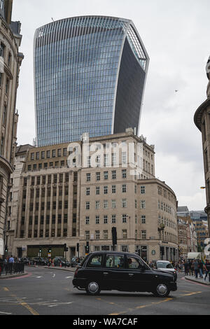 London, UK - August, 2019. Ein typischer Black Cab an einer Kreuzung in der Londoner City, dem Finanzviertel von London, mit dem berühmten Käse Reibe. Stockfoto