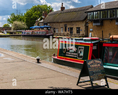 STOKE BRUERNE, NORTHAMPTONSHIRE, Großbritannien - 10. MAI 2019: Narrowboats, die auf dem Grand Union Canal festgemacht wurden, bieten Tagesausflüge an Stockfoto