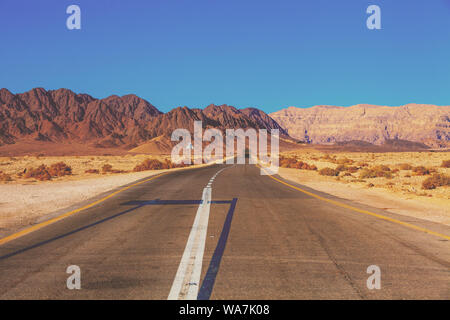 Das Autofahren auf den Berg Straße in Israel. Landschaft der Wüste. Leere Straße. Blick aus dem Auto der Berglandschaft an einem sonnigen Tag mit einem klaren blauen s Stockfoto