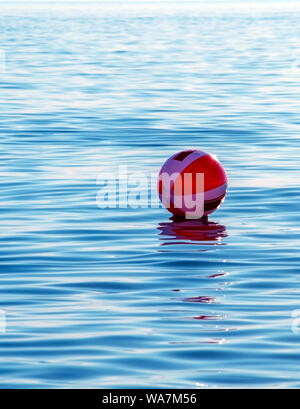 Eine rot-weiße Strand Kugel schwebt heraus und weg am Lake Michigan in den USA Stockfoto