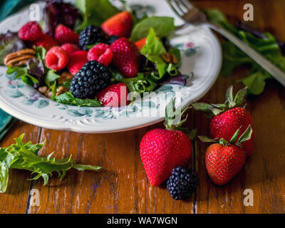 Schönen, gesunden Obst und grünem Salat auf einem Holztisch Stockfoto