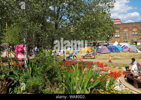 Zelte, Menschen und Blumengarten im Park am Aussterben Rebellion Protest in Waterloo Millennium Grün in South London SE1 England UK KATHY DEWITT Stockfoto