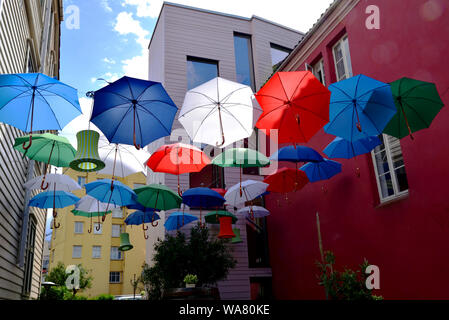 Bunte Sonnenschirme und Laternen zwischen zwei Gebäuden in Bergen, Norwegen ausgesetzt. Stockfoto