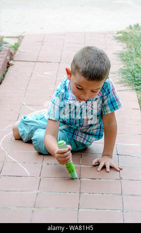 Junge mit Seite Chalk erstellen ein Bild auf dem Laufsteg Stockfoto