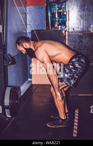 Muskulöse bärtigen Bodybuilder, die an der Turnhalle, die Übungen auf dem Kabel der Maschine Stockfoto