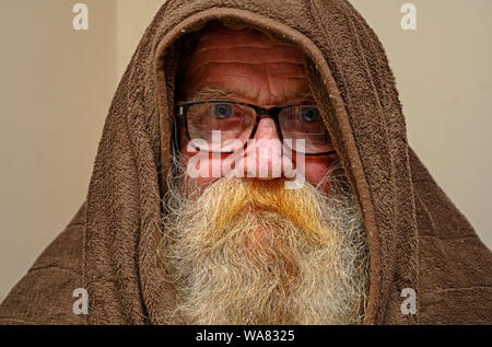 Ältere Mann mit Kapuze Decke warm zu halten Stockfoto