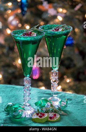 Special Weihnachten Flöten, die sagen, dass Noel, hält Sekt Champagner garniert mit einem Zweig Rosmarin, Scheibe Limette und Granatapfel Samen Stockfoto