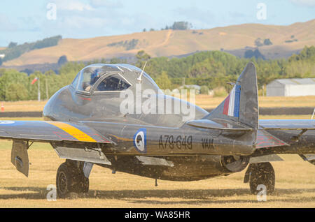 De Havilland Vampire jet Ebene am Flügel über Wairarapa Airshow, Haube Flugplatz, Masterton, Neuseeland. Rollen auf Gras oben weht Grasschnitt Stockfoto