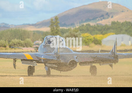 De Havilland Vampire jet Ebene am Flügel über Wairarapa Airshow, Haube Flugplatz, Masterton, Neuseeland. Rollen auf Gras oben weht Grasschnitt Stockfoto