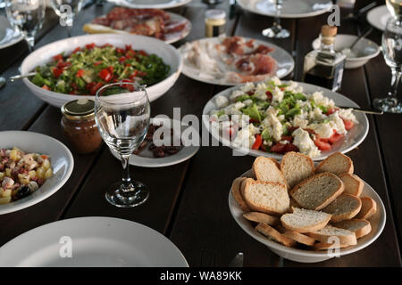 Mediterrane Salate und Antipasti auf ein gedeckter Tisch für ein rustikales Abendessen im Freien, ausgewählte konzentrieren, enge Tiefenschärfe Stockfoto