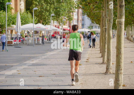 Mann oder runner Jog und am Rheinufer Promenade auf dem Bürgersteig laufen oder Walking Street am Ufer des Rhein in Düsseldorf, Deutschland. Stockfoto